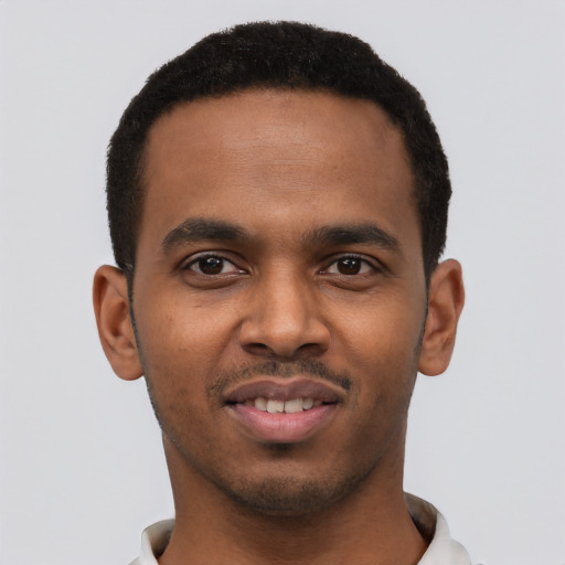 Joyful black young-adult male with short  black hair and brown eyes