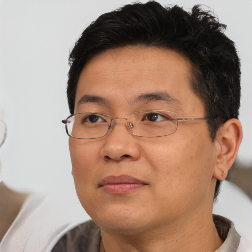 Joyful asian adult male with short  brown hair and brown eyes
