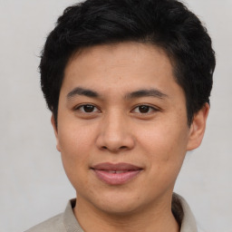 Joyful asian young-adult male with short  brown hair and brown eyes