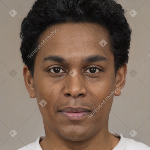 Joyful black young-adult male with short  black hair and brown eyes