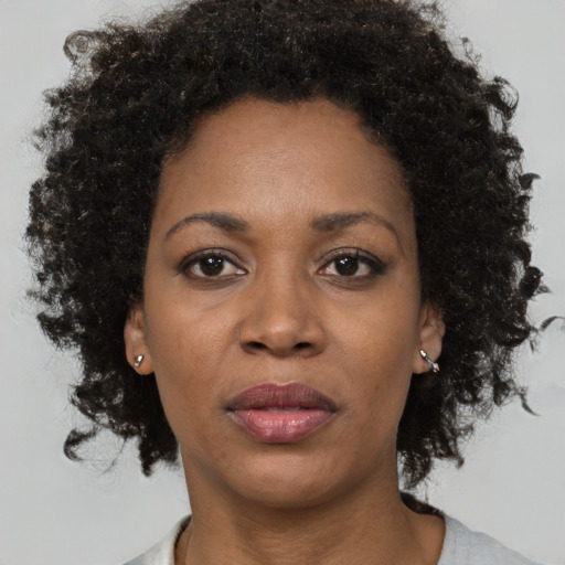 Joyful black adult female with short  brown hair and brown eyes