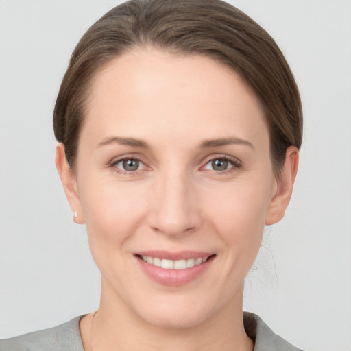 Joyful white young-adult female with short  brown hair and grey eyes