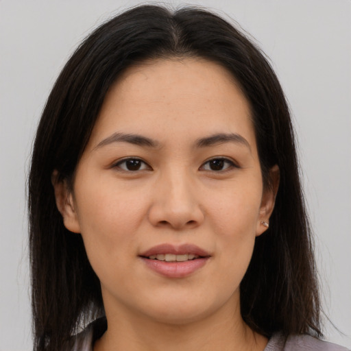 Joyful asian young-adult female with long  brown hair and brown eyes