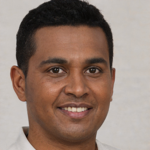 Joyful black young-adult male with short  brown hair and brown eyes