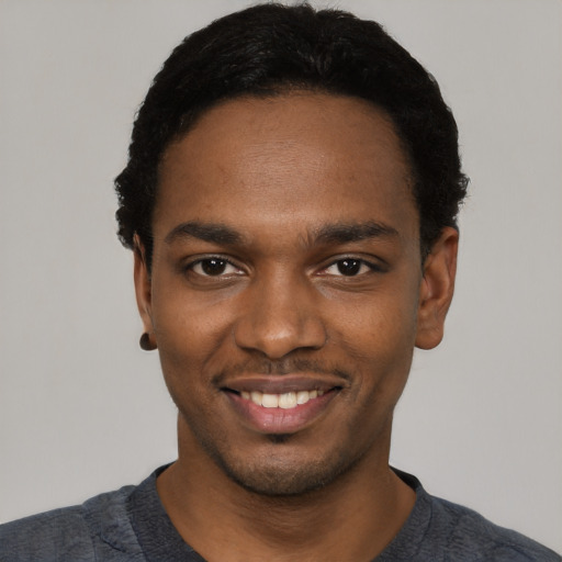 Joyful black young-adult male with short  black hair and brown eyes