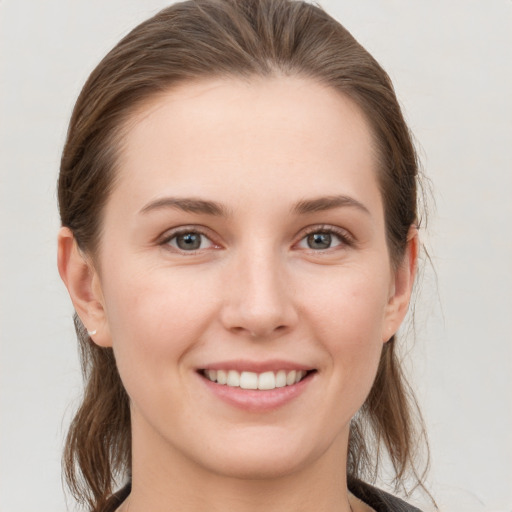 Joyful white young-adult female with medium  brown hair and grey eyes