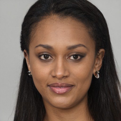 Joyful black young-adult female with long  brown hair and brown eyes