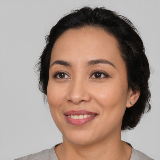Joyful latino young-adult female with medium  black hair and brown eyes