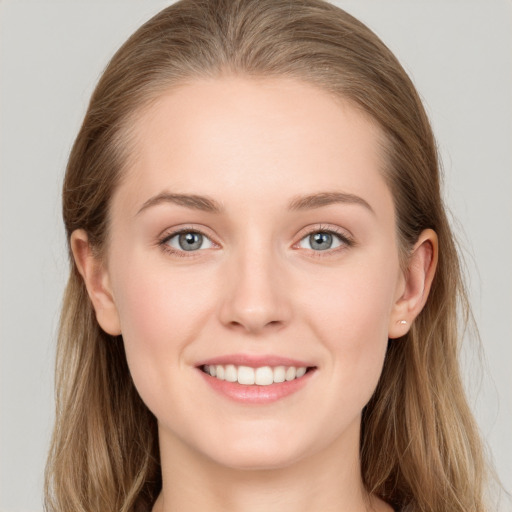 Joyful white young-adult female with long  brown hair and grey eyes