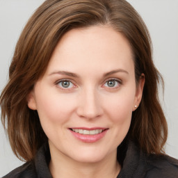 Joyful white young-adult female with medium  brown hair and grey eyes