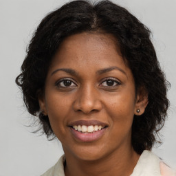 Joyful black young-adult female with medium  brown hair and brown eyes