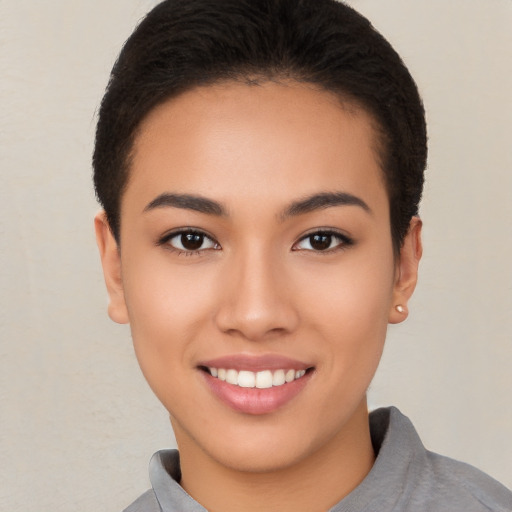 Joyful latino young-adult female with short  brown hair and brown eyes