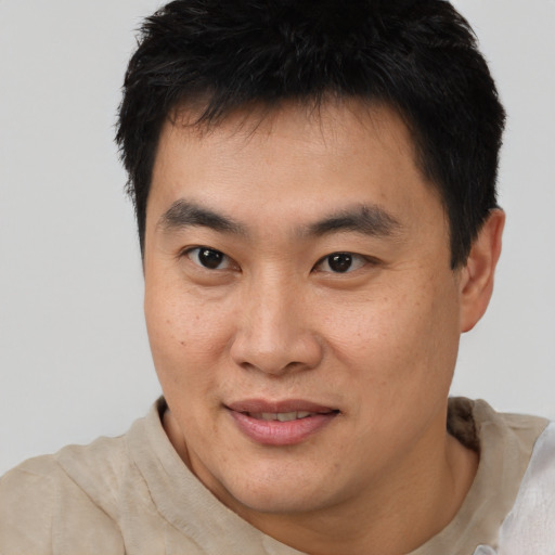 Joyful asian young-adult male with short  brown hair and brown eyes