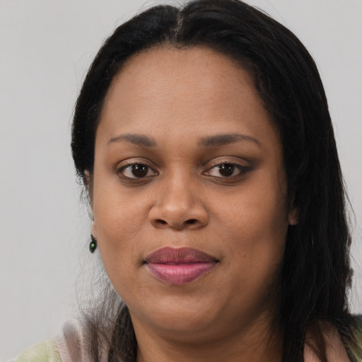 Joyful black young-adult female with long  brown hair and brown eyes