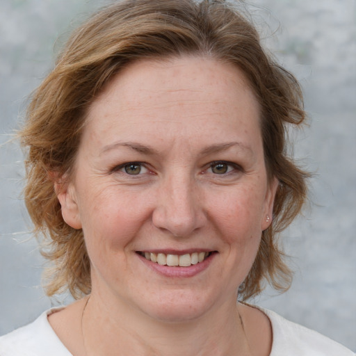 Joyful white adult female with medium  brown hair and blue eyes