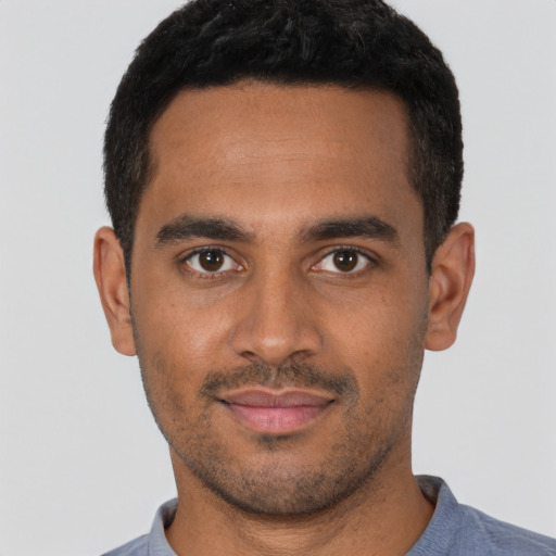 Joyful latino young-adult male with short  brown hair and brown eyes