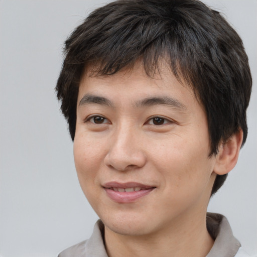 Joyful asian young-adult male with short  brown hair and brown eyes