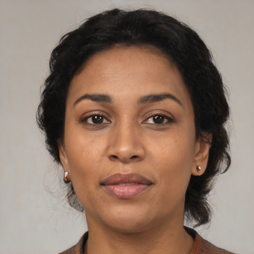 Joyful latino adult female with medium  brown hair and brown eyes