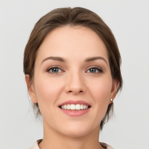 Joyful white young-adult female with medium  brown hair and grey eyes