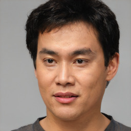 Joyful asian young-adult male with short  brown hair and brown eyes