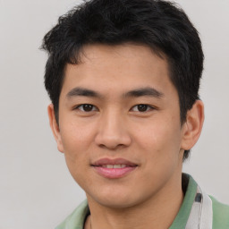 Joyful asian young-adult male with short  brown hair and brown eyes