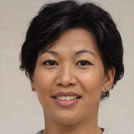 Joyful asian adult female with medium  brown hair and brown eyes