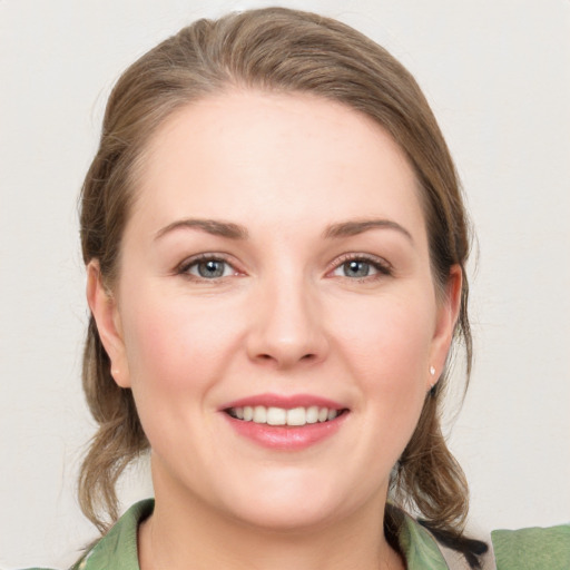 Joyful white young-adult female with medium  brown hair and grey eyes