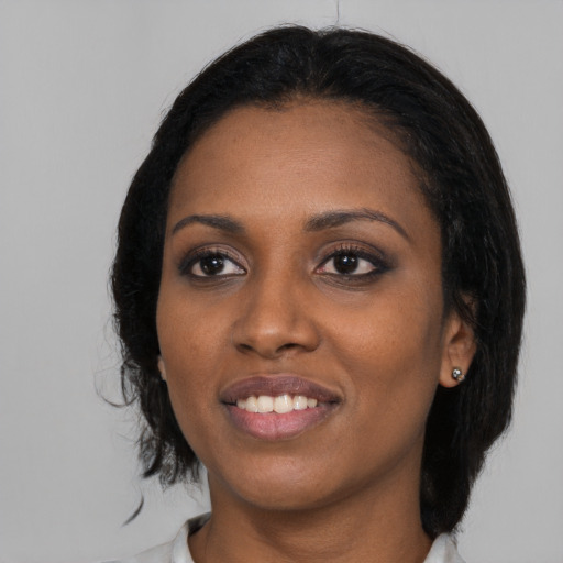 Joyful black young-adult female with medium  black hair and brown eyes