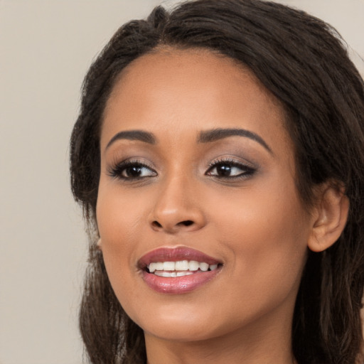 Joyful latino young-adult female with long  brown hair and brown eyes