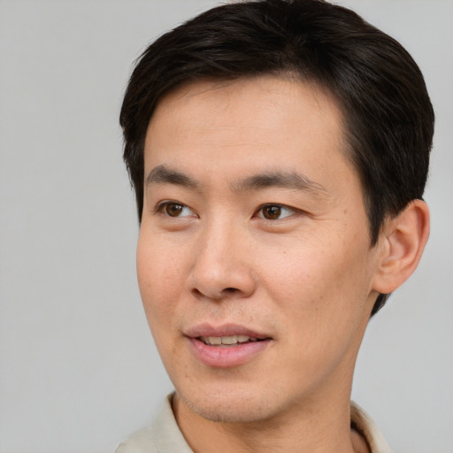 Joyful asian young-adult male with short  brown hair and brown eyes