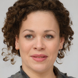 Joyful white young-adult female with medium  brown hair and green eyes