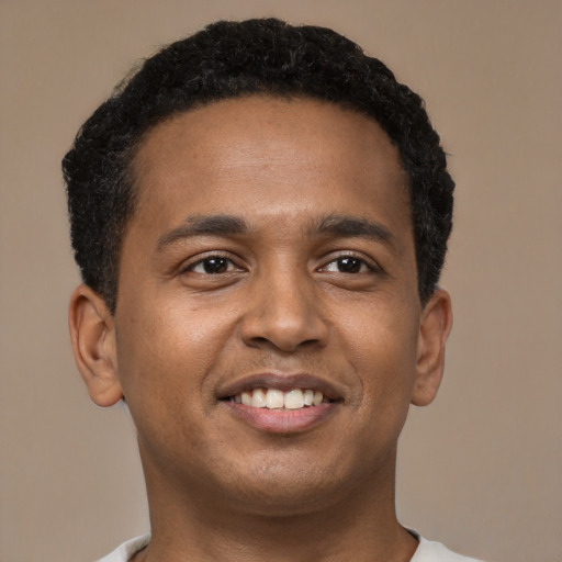 Joyful black young-adult male with short  brown hair and brown eyes