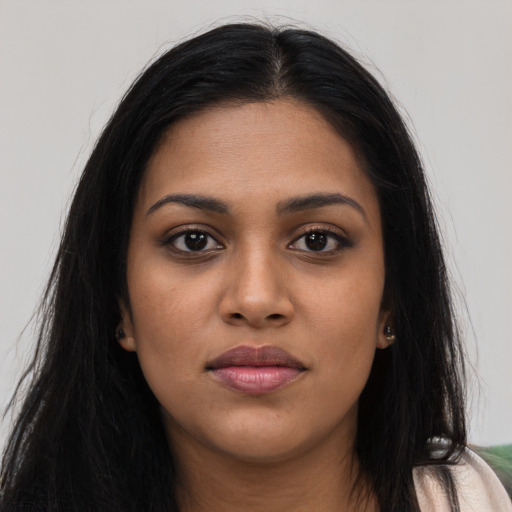 Joyful black young-adult female with long  brown hair and brown eyes