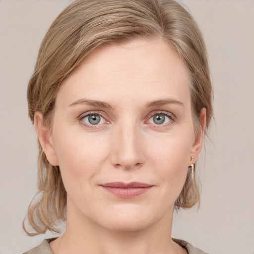 Joyful white young-adult female with medium  brown hair and blue eyes