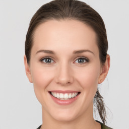 Joyful white young-adult female with medium  brown hair and grey eyes