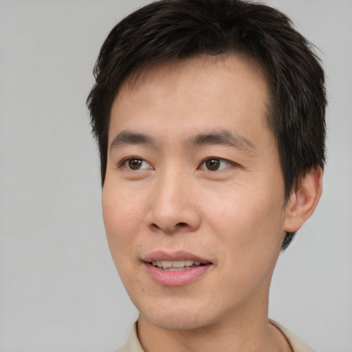 Joyful asian young-adult male with short  brown hair and brown eyes