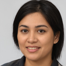 Joyful latino young-adult female with medium  brown hair and brown eyes