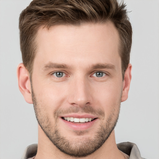 Joyful white young-adult male with short  brown hair and grey eyes