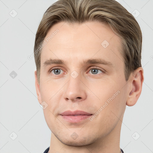 Joyful white young-adult male with short  brown hair and grey eyes