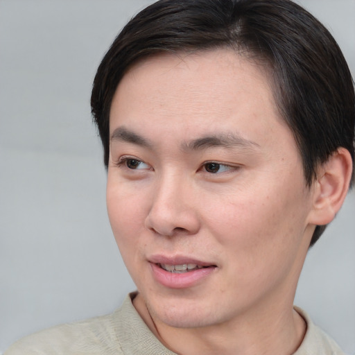Joyful asian young-adult male with short  brown hair and brown eyes