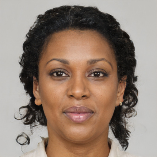 Joyful black adult female with medium  brown hair and brown eyes