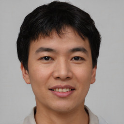 Joyful asian young-adult male with short  black hair and brown eyes