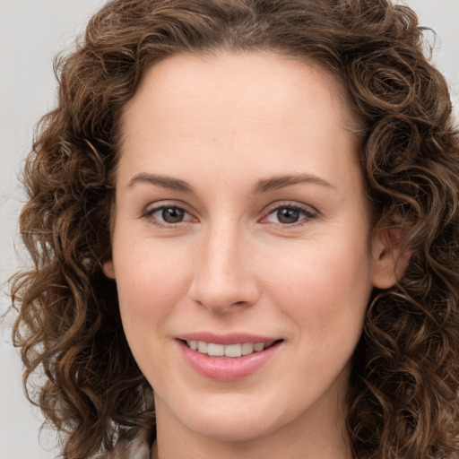 Joyful white young-adult female with long  brown hair and green eyes