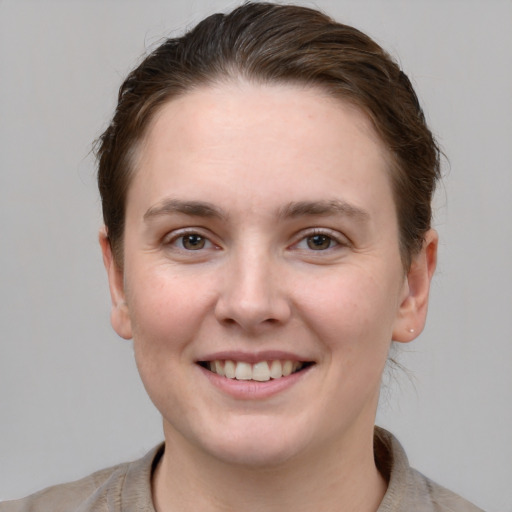 Joyful white young-adult female with short  brown hair and grey eyes