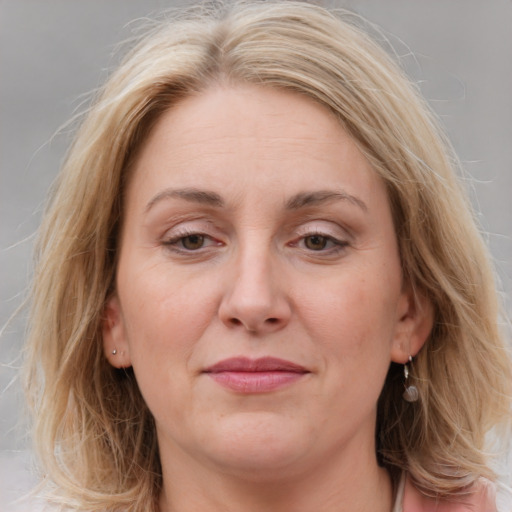 Joyful white adult female with medium  brown hair and blue eyes