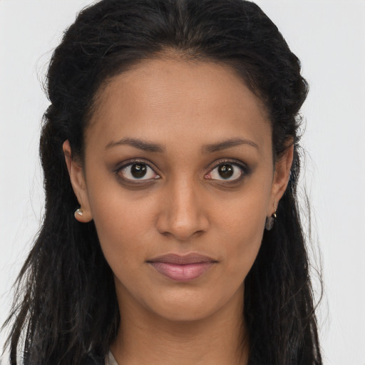 Joyful black young-adult female with long  brown hair and brown eyes