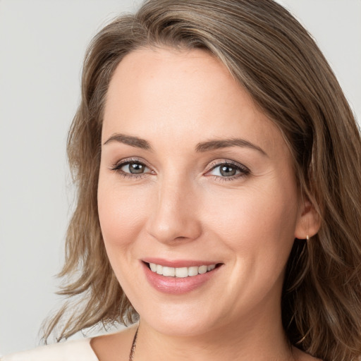 Joyful white young-adult female with long  brown hair and grey eyes