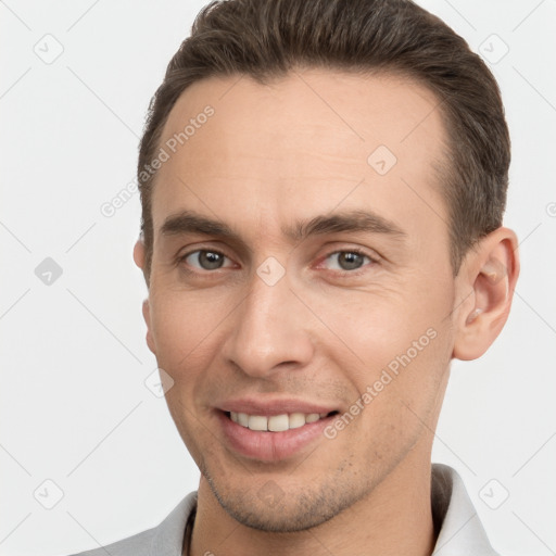 Joyful white young-adult male with short  brown hair and brown eyes