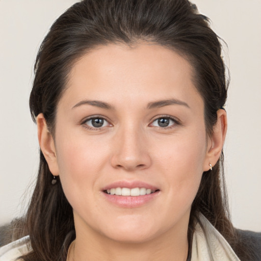 Joyful white young-adult female with long  brown hair and brown eyes