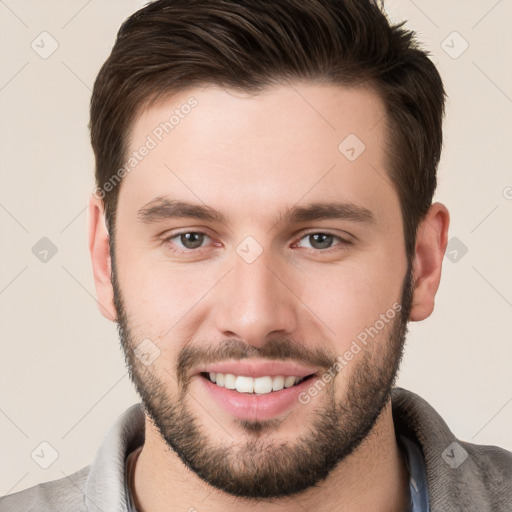 Joyful white young-adult male with short  brown hair and brown eyes